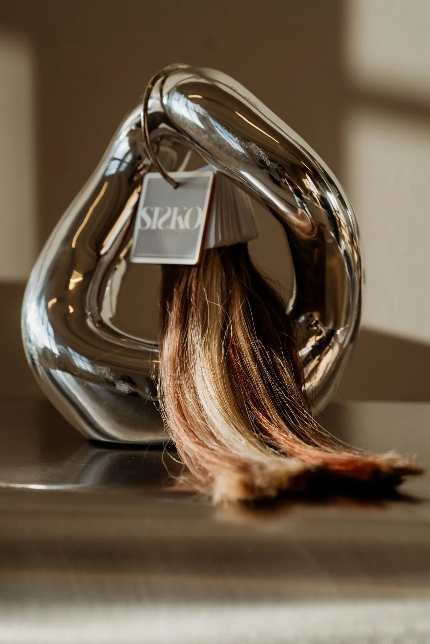 SISKO hairweave met label op een sculptuur